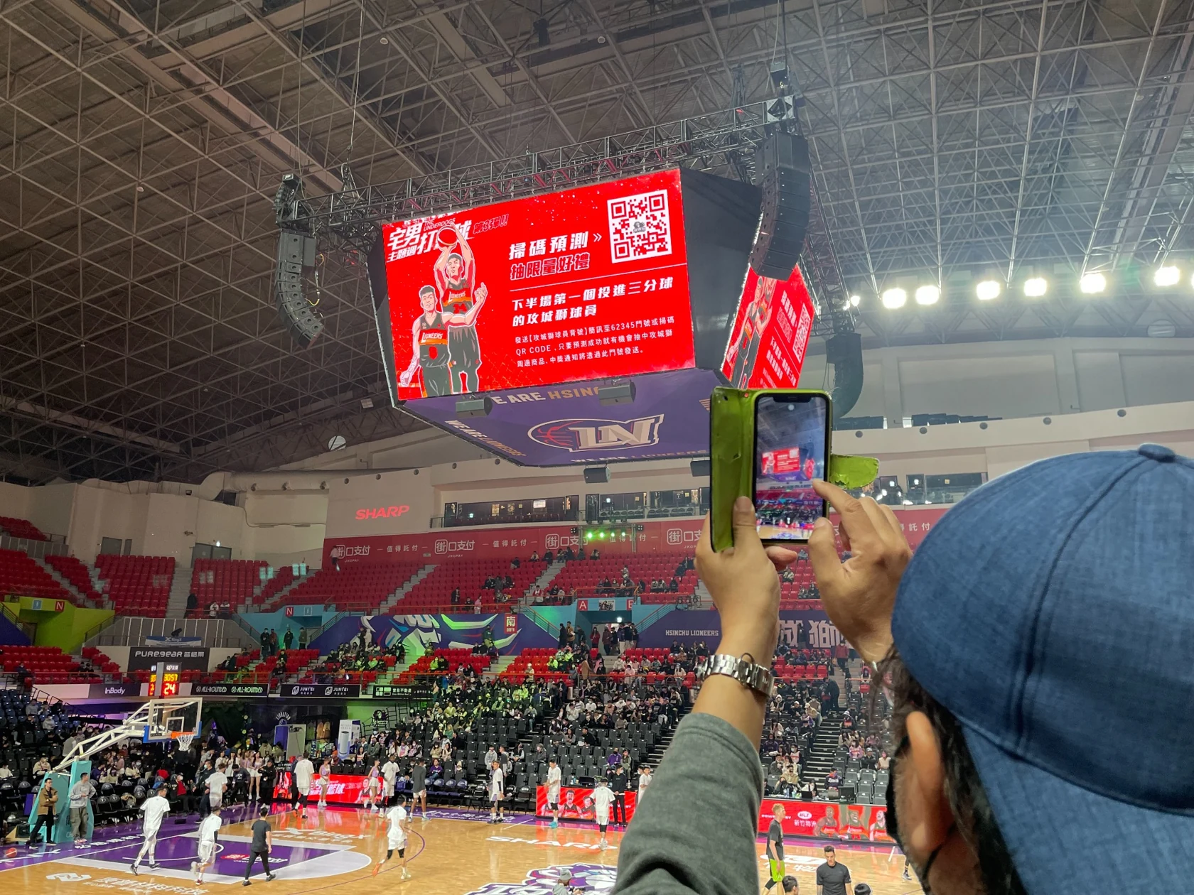 觀眾用手機鏡頭對準球場螢幕上的QR Code。